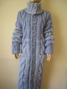 a mannequin wearing a blue cabled coat and turtle - neck sweater dress