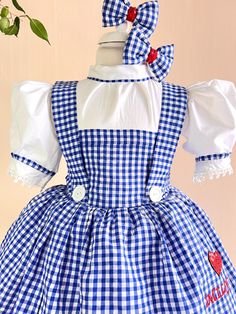 a blue and white checkered dress with red hearts on the chest, two bows at the back