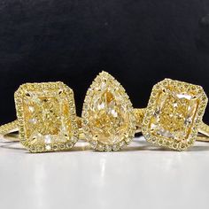 three fancy yellow diamond rings sitting on top of each other