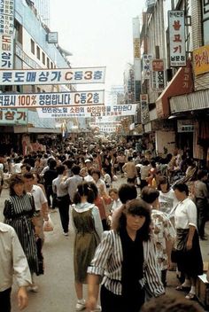 many people are walking down the crowded street