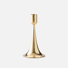 a brass candle holder on a white background with no one in the photo to describe it