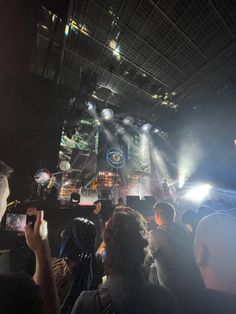 a group of people standing in front of a stage with lights and sound equipment on it