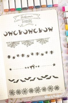 a notebook with halloween dividers and spider webs on the cover, surrounded by crayons