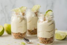 three mason jars filled with dessert and limes