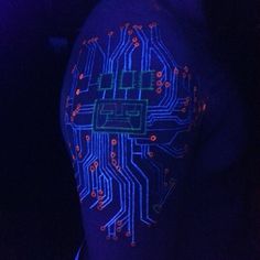 the back of a man's arm with an electronic circuit printed on it