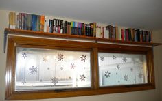 the books are on top of the window sill in the room that is decorated with snowflakes