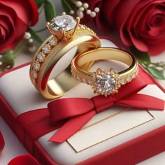 two gold wedding rings sitting on top of a red box with roses in the background