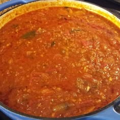 a blue pot filled with food sitting on top of a stove