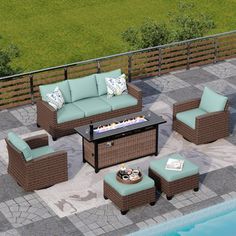 an outdoor patio furniture set with blue cushions and coffee table next to a swimming pool