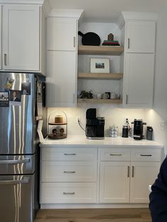 a kitchen with white cabinets and stainless steel appliances