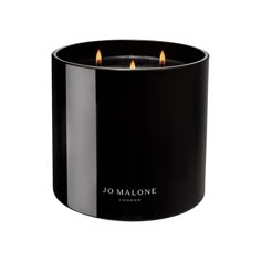 a black candle holder with three candles in it and the words jo malle on top