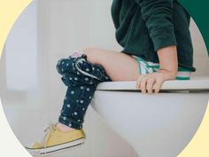 a young child sitting on top of a toilet with their legs propped against the seat