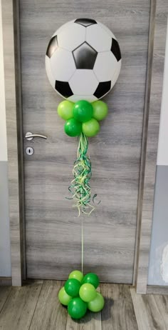 a soccer ball and some green balloons in front of a door