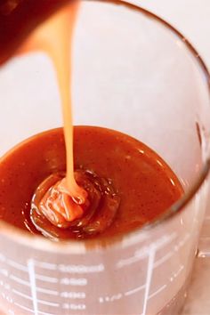 someone pouring caramel sauce into a blender