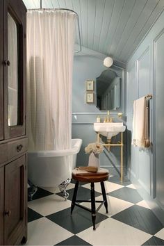 a bathroom with black and white checkered flooring, a bathtub and sink