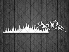 mountains and trees cut out of paper on a wooden background with the word mountain above them