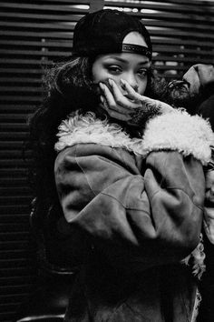 a black and white photo of a woman covering her mouth