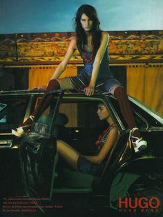 a woman sitting on top of a car next to another woman