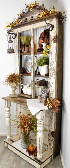 an old cabinet is decorated with fall leaves and other things to decorate in the corner