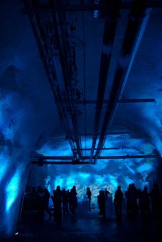 people are standing in a tunnel with blue lights