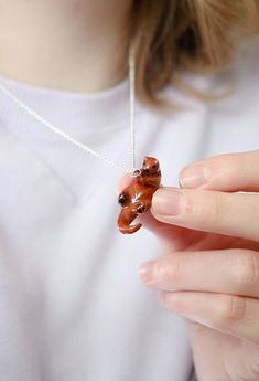 This cute sea otter necklace is the perfect accessory for any otter lover.  This pendant is about 1 inch wide and comes on a 22 inch silver plated chain.  This piece is handmade by myself, Anna, in my small home pottery studio, alongside everything else in the shoppe. The figurine is hand sculpted, hand glazed, and fired by myself in my studio.  Because all of my pieces are handmade, there will be variances between all pieces, be it color, size, or general looks. My pottery style embraces the natural aesthetic imperfections found in the craft to give my pieces a genuine, handmade feel. Colors may appear slightly different in person due to lighting, camera, and tablet/computer screen variances. Otter Clay Dish, Clay Otter, Ceramic Otter Sculpture, Otter Ceramic, Cute Sea Otter, Home Pottery Studio, Otter Necklace, Cottagecore Necklace, Home Pottery