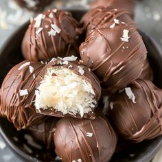 a bowl filled with chocolate covered truffles on top of a table