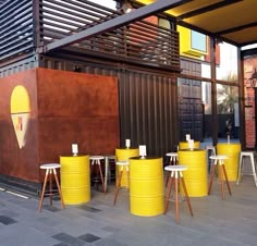 yellow stools and tables in front of a building