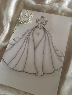 a drawing of a wedding dress with a flower in the middle on a white sheet