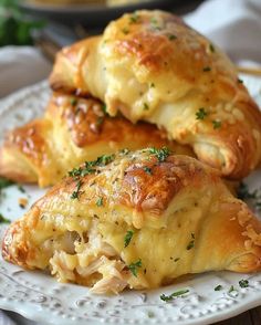 two croissants on a white plate with parmesan cheese and herbs