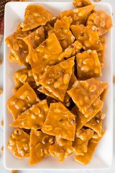 a white plate topped with caramel brittles on top of a marble countertop