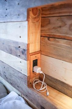 an electrical outlet is plugged into a wooden wall paneled in wood planks