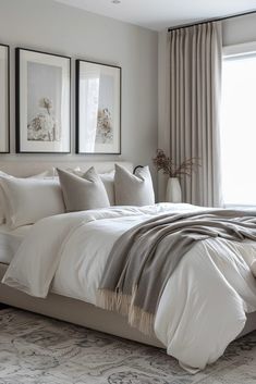 a large bed sitting in a bedroom next to two framed pictures