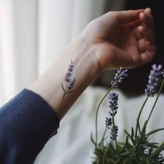 a woman's wrist with lavender flowers on it