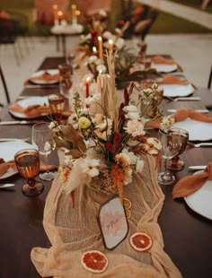 the table is set with candles, plates and napkins