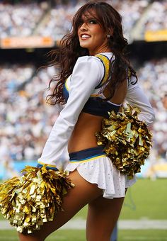 a cheerleader is posing for the camera at a football game