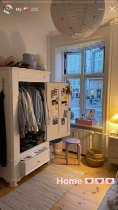 a room with a white cabinet and some clothes