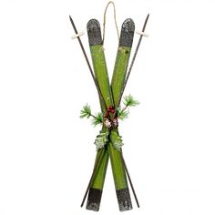 two green skis with bows and holly on them