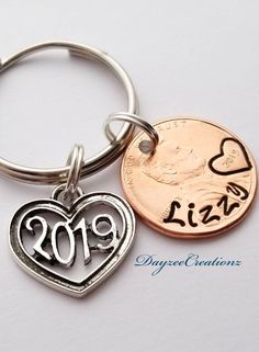 a keychain with a heart and the date 2009 on it, next to a penny