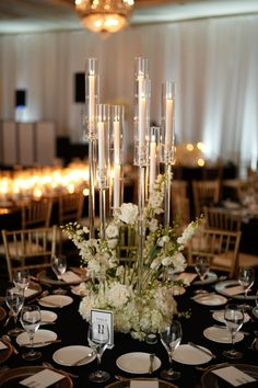 an elegant centerpiece with candles and flowers is displayed on a table in the ballroom