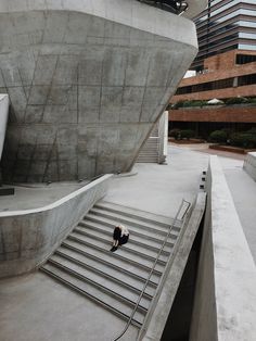 there is a person sitting on the stairs in front of a building that looks like a boat