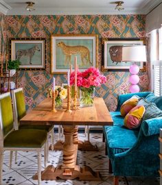 a living room with blue couches and colorful wallpaper on it's walls