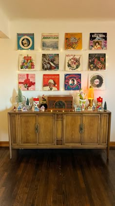 a wooden sideboard with many posters on it