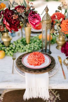 the table is set with flowers and place settings