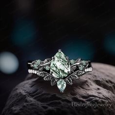 a ring with green stones and leaves on it