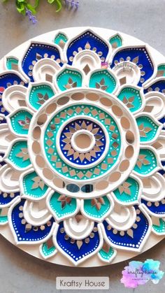 an intricately designed plate with blue and green designs on the front, sitting on a table