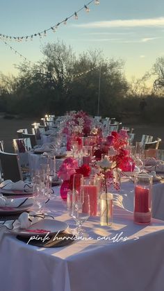 the table is set with pink flowers and candles