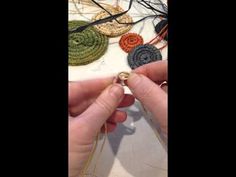 someone is working on some crocheted items with scissors and thread in their hands