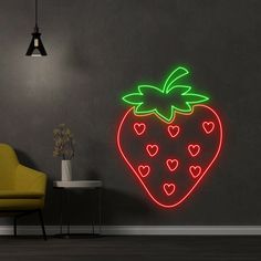 a neon strawberry with hearts on it is lit up in the corner of a room