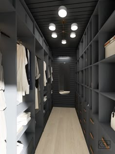 a walk - in closet with black shelving and wooden flooring