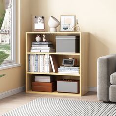 a living room with a couch, chair and bookshelf in front of a window